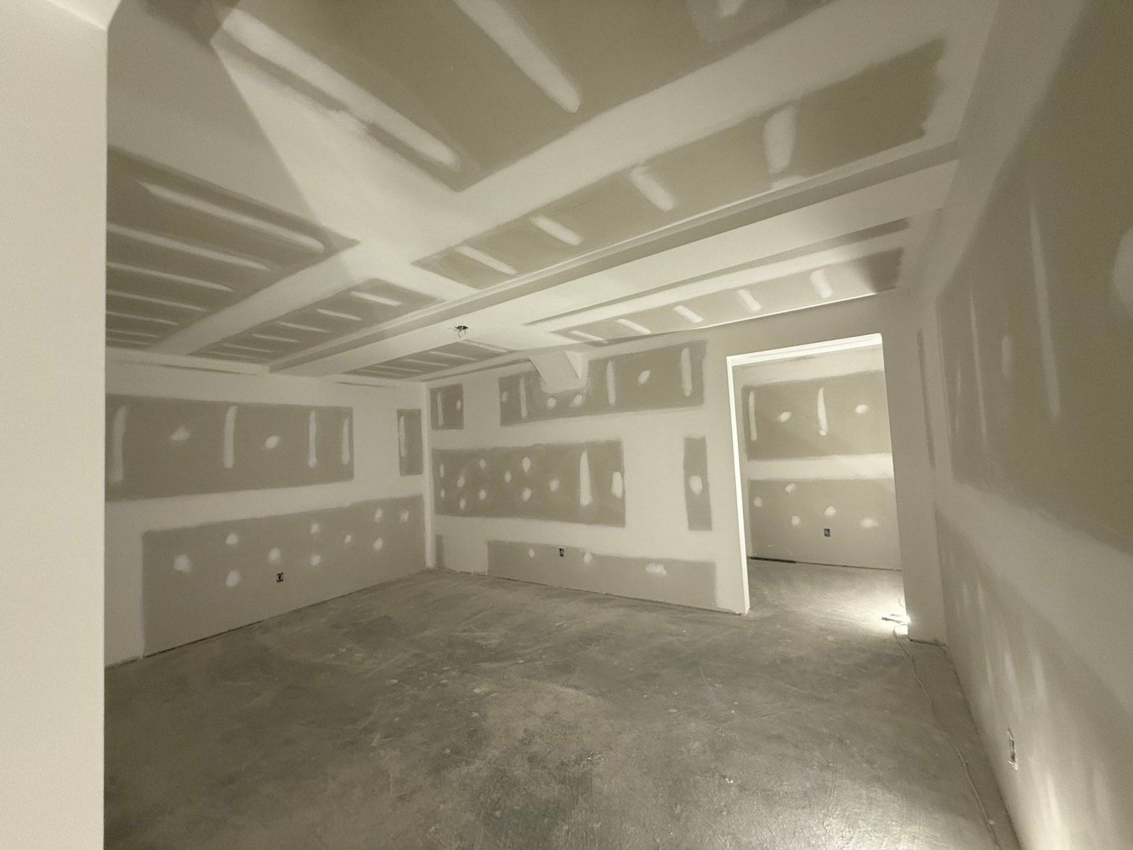 Room with new drywall hung and taped, ready for finishing