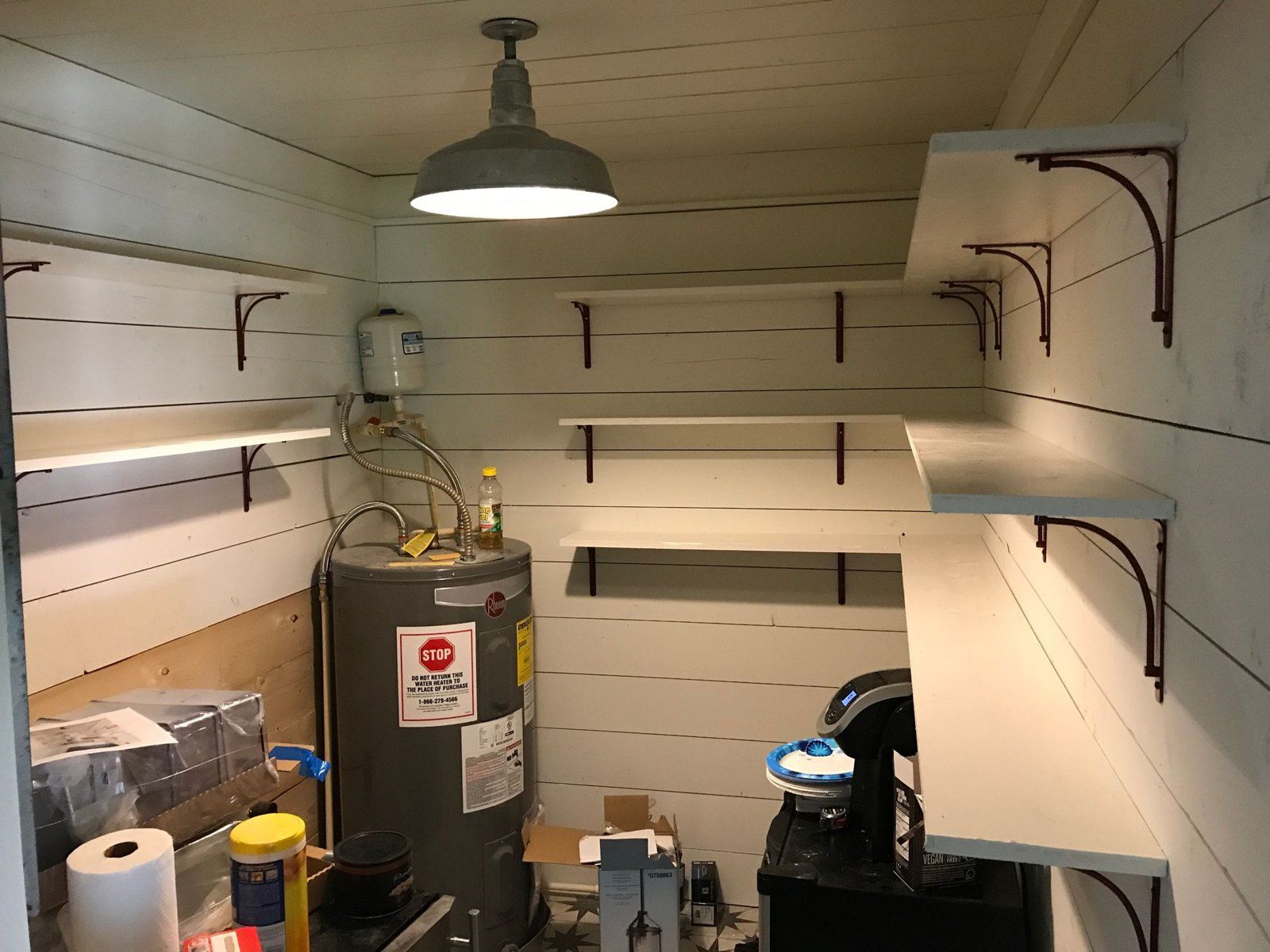 Finished utility room with shiplap walls, shelving and a pendant light