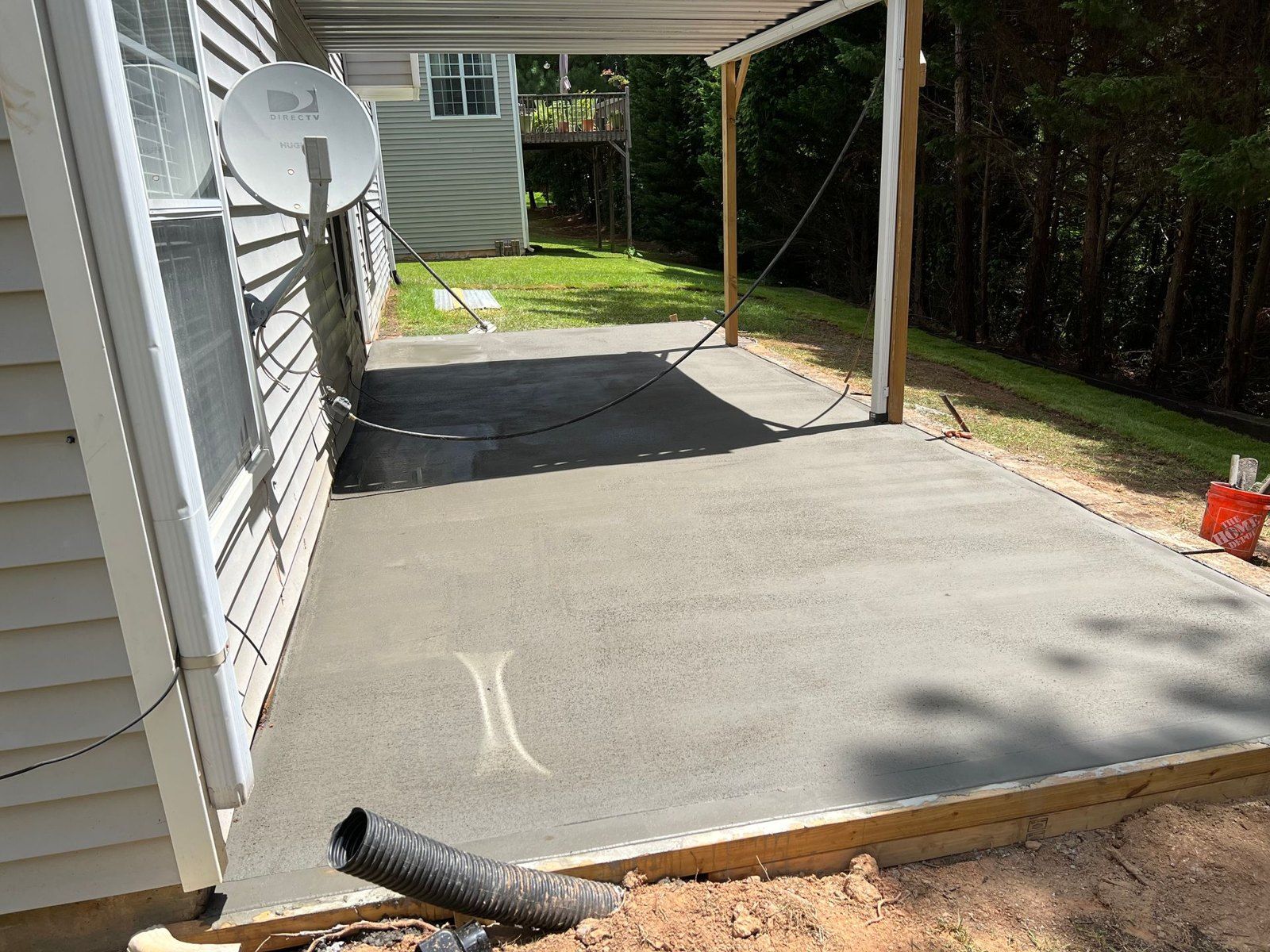 New concrete patio slab poured under a covered back porch